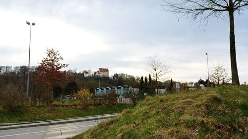 Street amidst field against sky