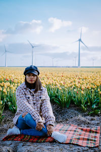 Woman with umbrella on field against sky