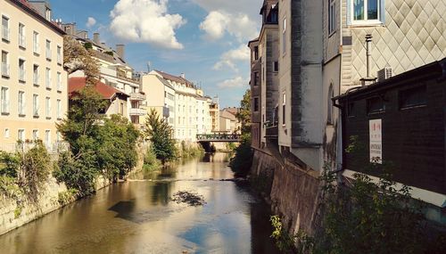 Canal amidst buildings against sky