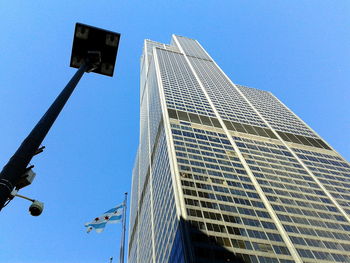 Low angle view of skyscraper against blue sky
