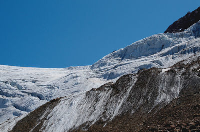 Scenic view of snowcapped mountains against clear blue sky