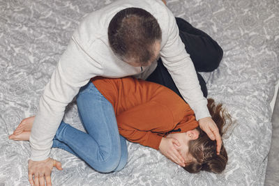 High angle view of woman sitting on bed at home