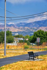 Empty bench on landscape against sky