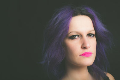 Portrait of a beautiful young woman over black background