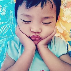 Close-up of baby girl on bed