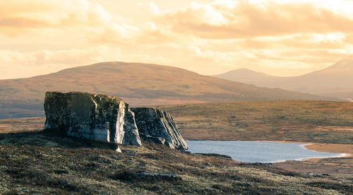 Scenic view of land and mountains against sky