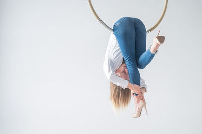 Rear view of woman holding rope against white background