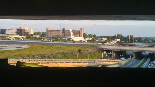 Bridge over river by cityscape against sky