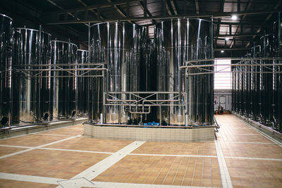 Rows of shiny stainless steel reservoirs placed in bright industrial area of modern factory