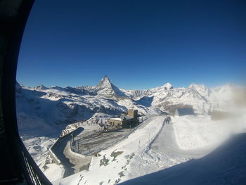 Panoramic view of snowcapped mountains against clear blue sky