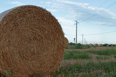 Hay bales on field against sky