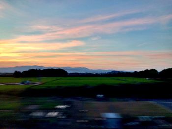 Scenic view of field against sky at sunset