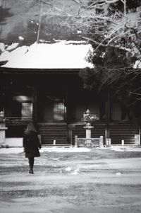 Full length rear view of woman walking in city