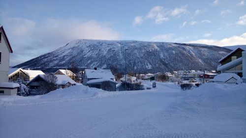 Houses on snowcapped mountain against sky