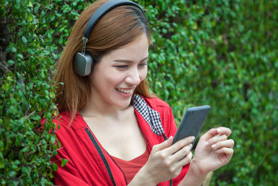 Smiling young woman using mobile phone