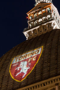 Low angle view of illuminated text against sky at night