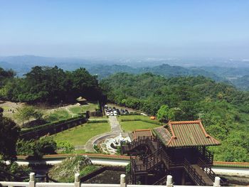 High angle view of building against green mountains and sky on sunny day