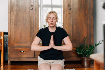 Mature woman meditating at home