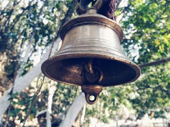 Low angle view of metal hanging on tree