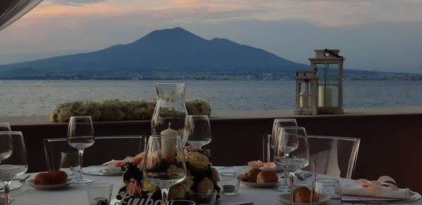 People at restaurant by mountains against sky