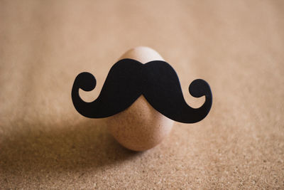 High angle view of artificial mustache on egg