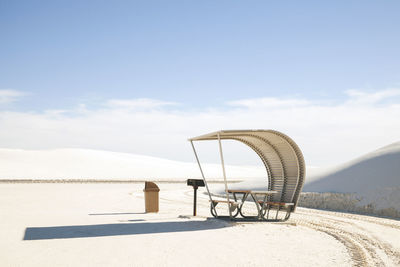 Hooded beach chair at white sands national monument against sky