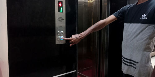 Midsection of man standing in elevator