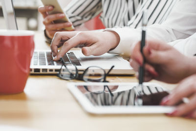 Midsection of man using laptop on table