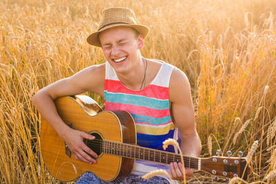 Portrait of a smiling young man playing guitar