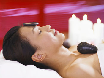 Woman having lastone therapy while lying on massage table