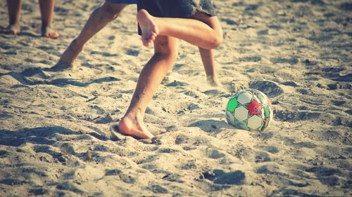 Low section of person with ball on beach