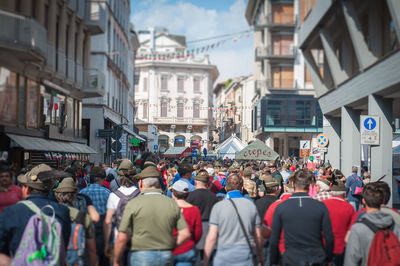 People on street amidst buildings in city