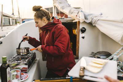 Woman cooking meal on boat