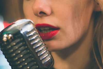 Midsection of woman singing using microphone at event