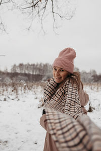 Portrait of woman standing on snow covered land