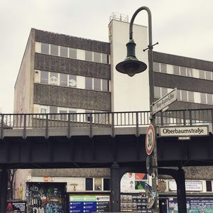 Low angle view of illuminated street light in city against sky