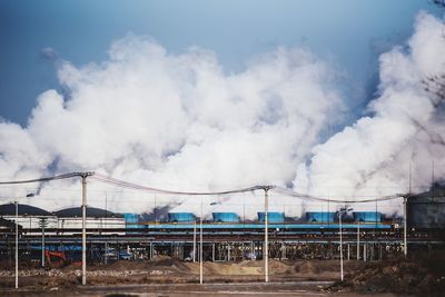 Factory emitting smoke against sky