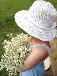 Rear view of woman standing by flowering plants