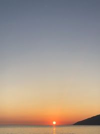 Scenic view of sea against clear sky during sunset