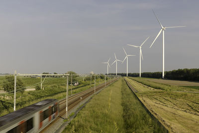 Railroad amidst field against sky