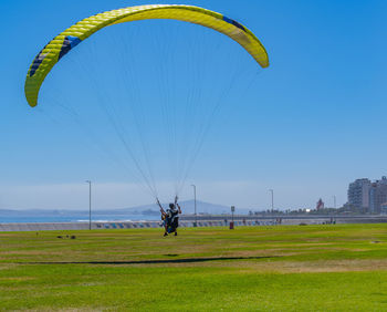 Low angle view of person paragliding against sky