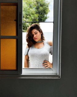 Portrait of woman standing by window