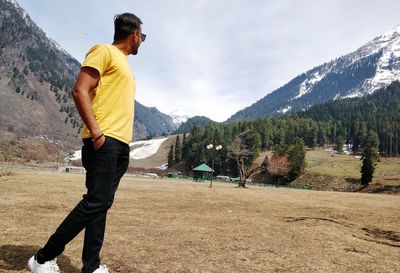 Man standing on mountain against sky