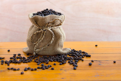 Close-up of roasted coffee beans in sack on table