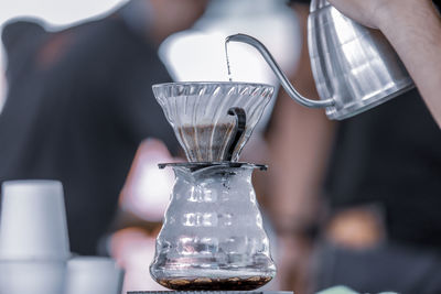 Close-up of hand pouring coffee cup