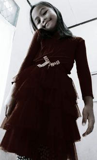 Young woman standing against white wall