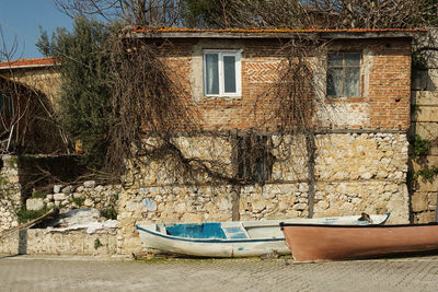 Boats moored by house against trees