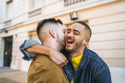 Gay couple embracing while standing outdoors