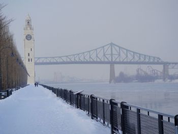 Bridge over river against clear sky during winter