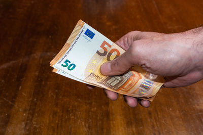 Close-up of hand holding text on table